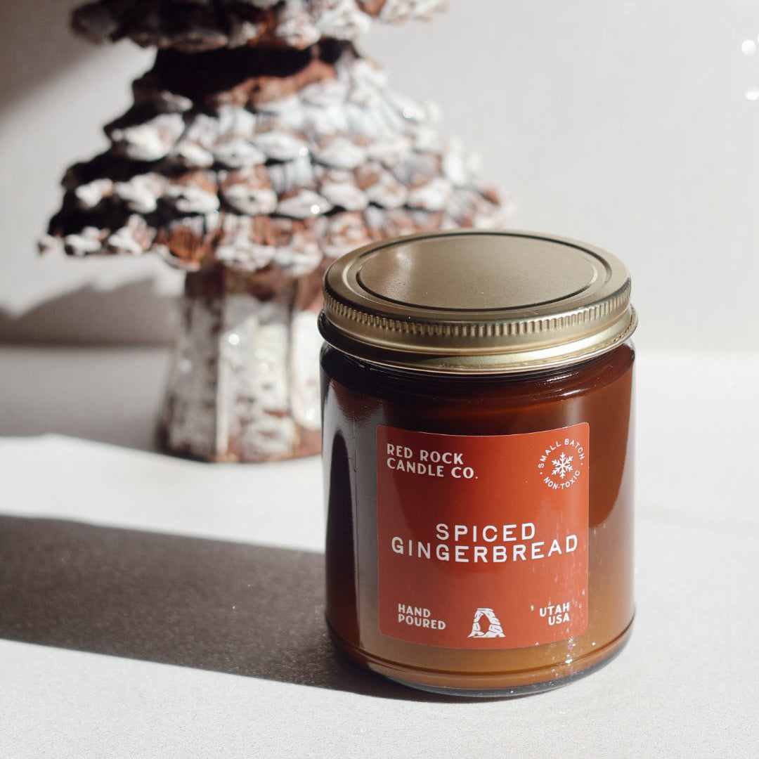 Spiced gingerbread candle with decorative tree in the background